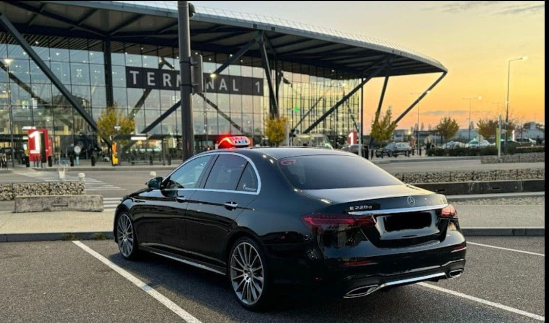 Berline Mercedes noire, taxi, garée devant le Terminal 1 de l'aéroport Lyon-Saint Exupéry